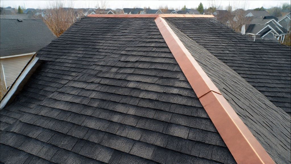 Copper strip installation along roof ridge to prevent algae growth and protect shingles from dark staining