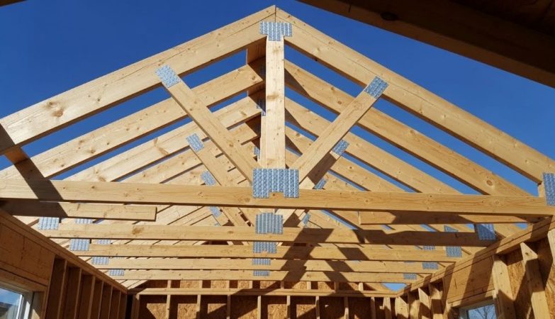 Gable roof framing structure showing rafters, ridge board, and ceiling joists on a small residential home