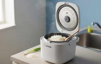 Compact Zojirushi 3-cup rice cooker on small apartment kitchen counter with fresh cooked rice